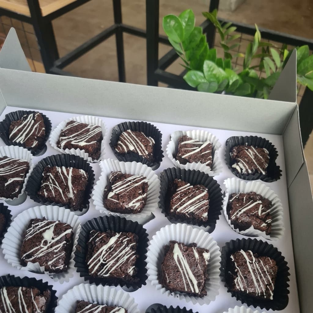 Box of fudge brownies with white chocolate drizzle