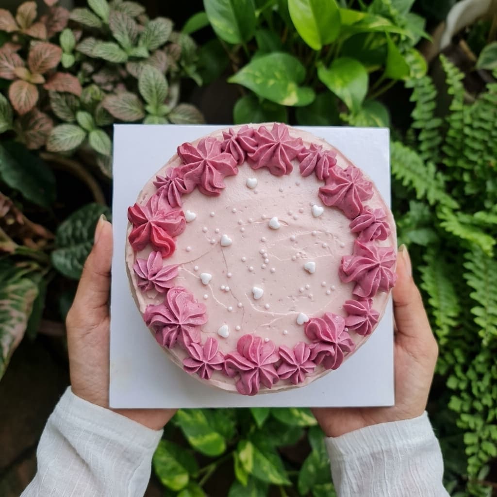 Pink buttercream cake with a piped rosette border